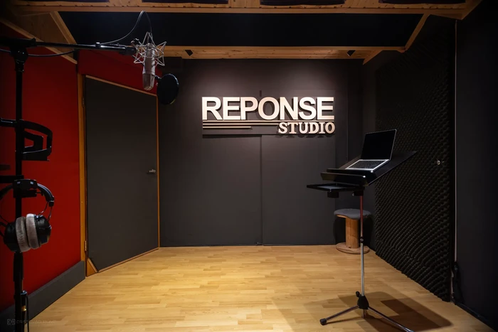 Cabine du studio d’enregistrement Reponse Studio avec traitement acoustique, lumière douce et espace dédié aux prises de voix professionnelles.