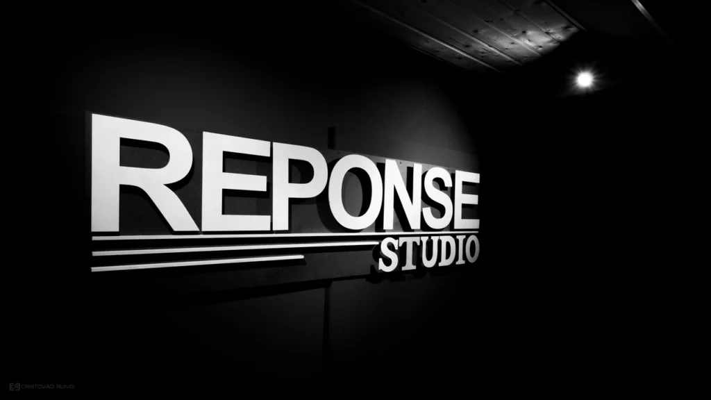 Logo Reponse Studio dans la cabine d’enregistrement, espace dédié à la création musicale avec une acoustique précise et une ambiance propice à la performance.
